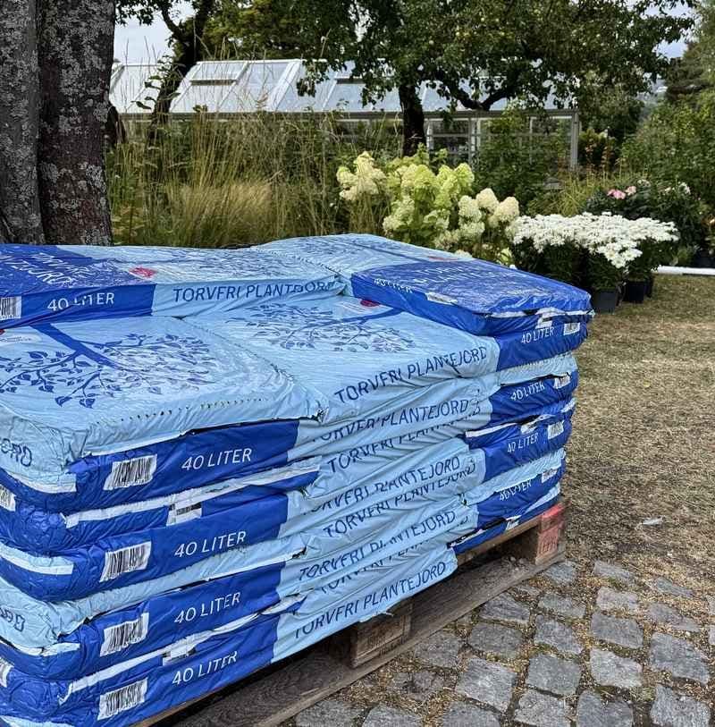 Pall med plantejord i blå sekker. Foto. 