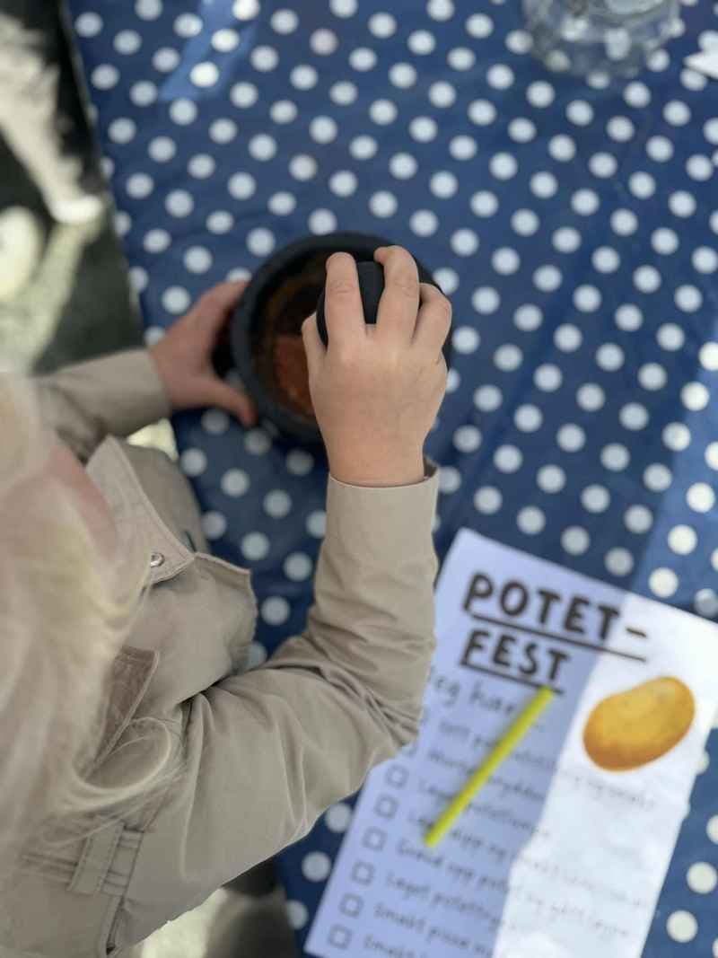 Barn delar i potetløp ved åpning av kjøkkenhage. foto. 