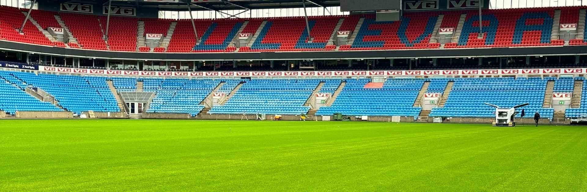 Ny gressmatte på Ullevaal Stadion med tribunene i bakgrunnen. Foto.