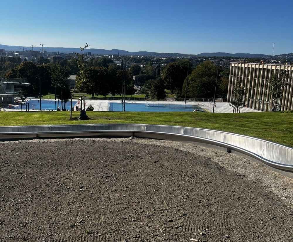 Uteområde med vannsklie og gressterrasser ved Tøyenbadet